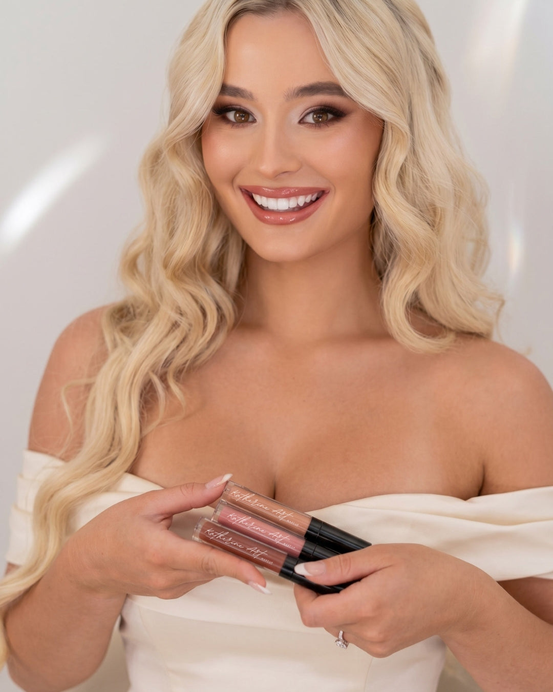 Model holding the Katherine Art Long-Wear Liquid Lipstick nude collection, featuring long-lasting matte nude lipsticks with comfortable wear for everyday and bridal makeup.