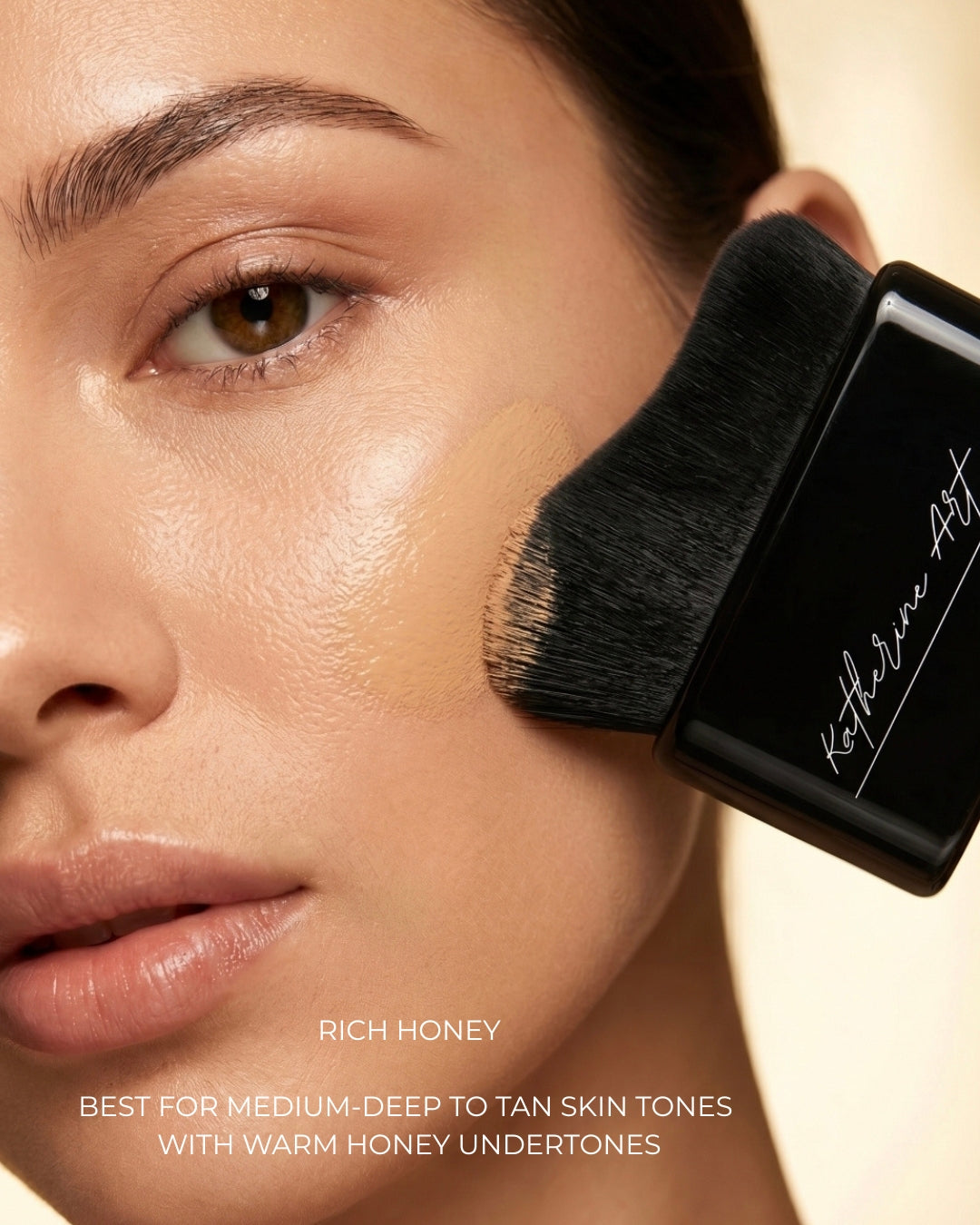 Model applying Katherine Art Sheer Skin Tint SPF55 in Rich Honey using the Katherine Art Kabuki Brush, showcasing lightweight buildable coverage with a natural radiant finish for medium-deep to tan skin tones.